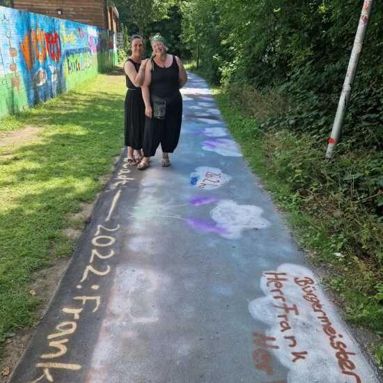 Zwei Frauen stehen auf einem von Schülern bemalten Weg