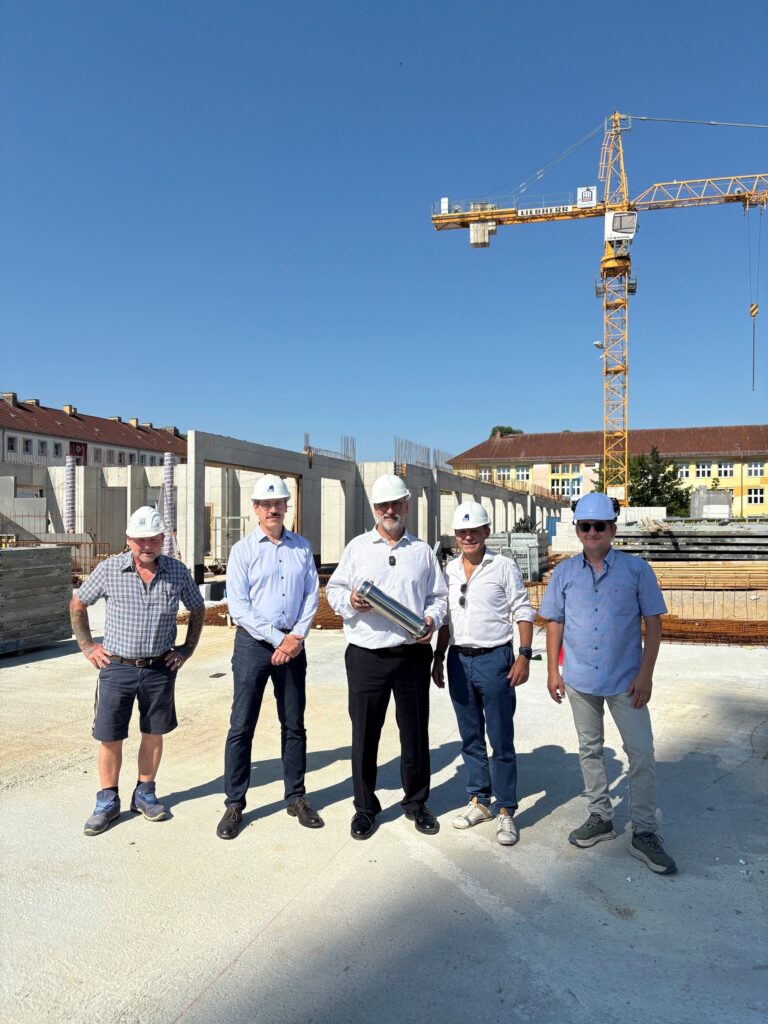 Einbringen der Zeitkapsel in den Grundstein. Bürgermeister Frank Nerlich mit den Projektbeteiligten.